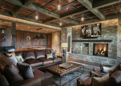 Blue Mist Custom Home Family Bar 3 Wood. The ashlar stone fireplace warms up the family room. Check out the coffered ceiling detail, adding a bold pattern to this luxury custom home in Blairsville Georgia