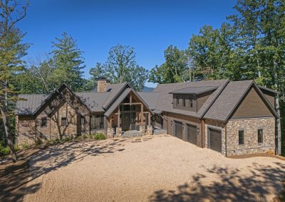 Blue Mist Custom Home Front 1. Stone, hewn log siding, board and batten and shakes clad Blue Mist Lodge, to give it a classic yet rustic custom home style in Blairsville Georgia