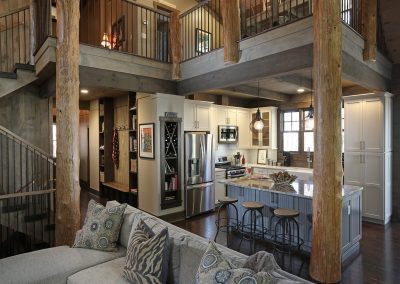 Rustic interior with peeled log beams supporting loft and roof structure in Jasper, Georgia by Modern Rustic Homes